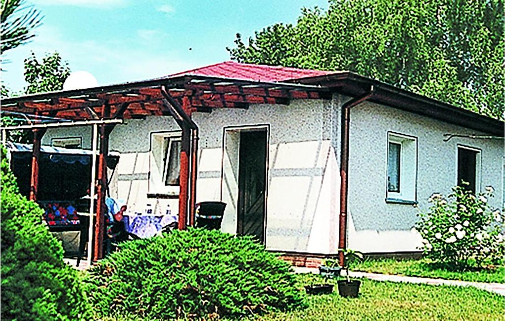 a small white house with a red roof at Holiday Home Am Wiesengrund V in Löcknitz