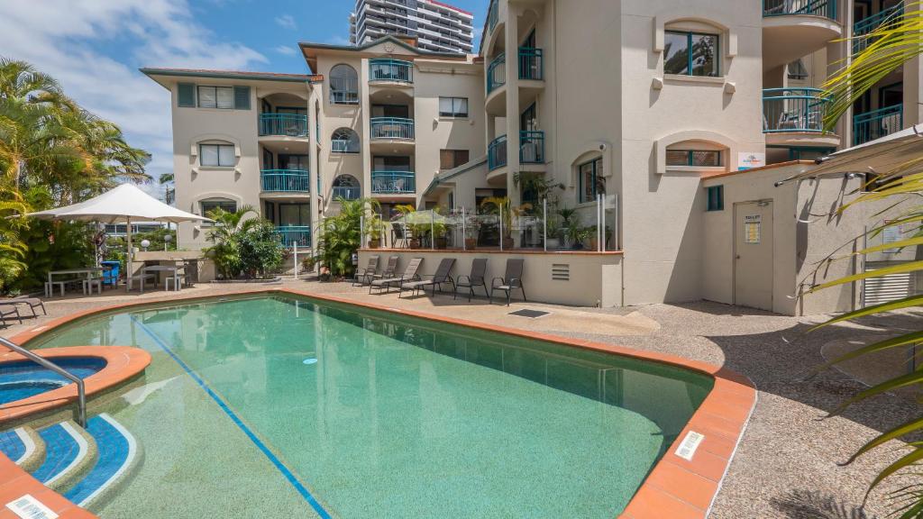 a swimming pool in front of a apartment building at Aruba Beach Resort in Gold Coast