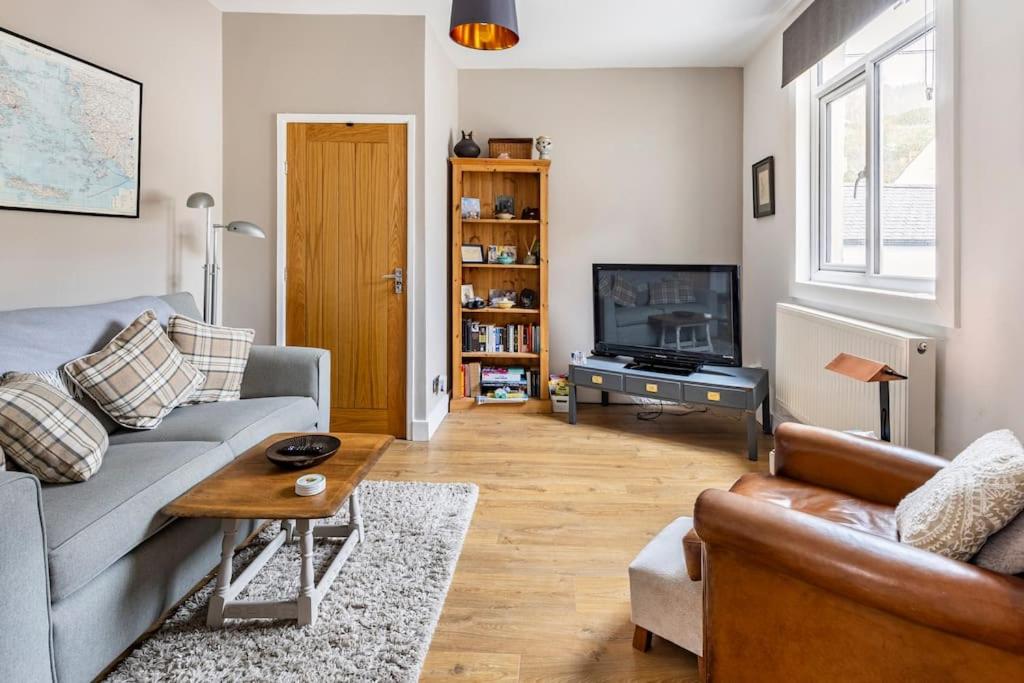 a living room with a couch and a television at Castell Bach in Llangollen