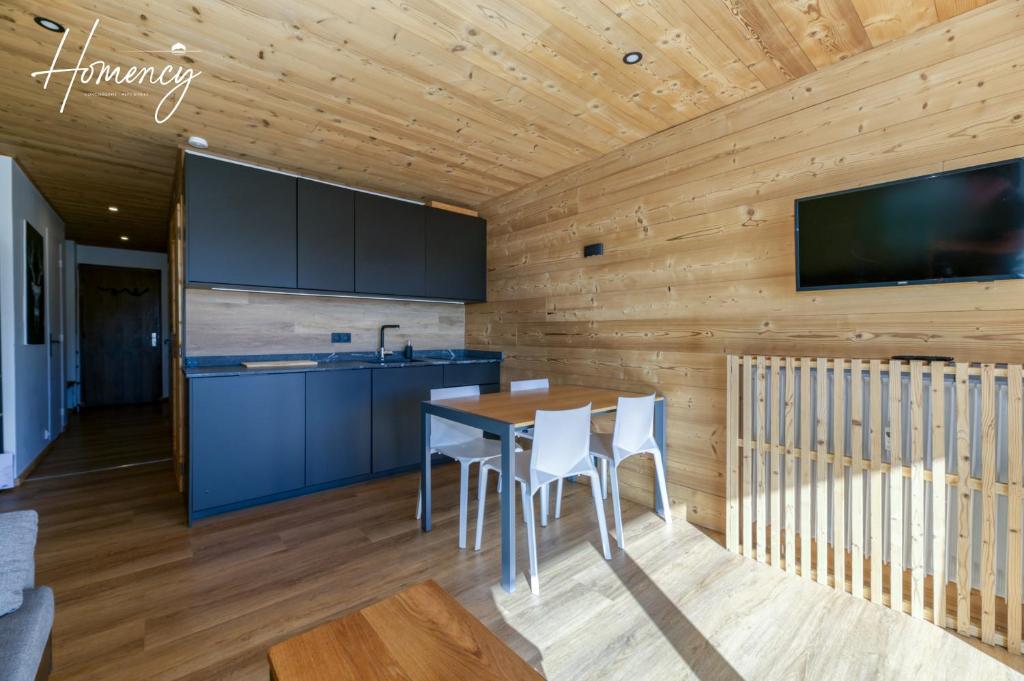 une cuisine et une salle à manger avec une table et des chaises dans l'établissement Homency - Résidence le Majestic N2, à L'Alpe-d'Huez