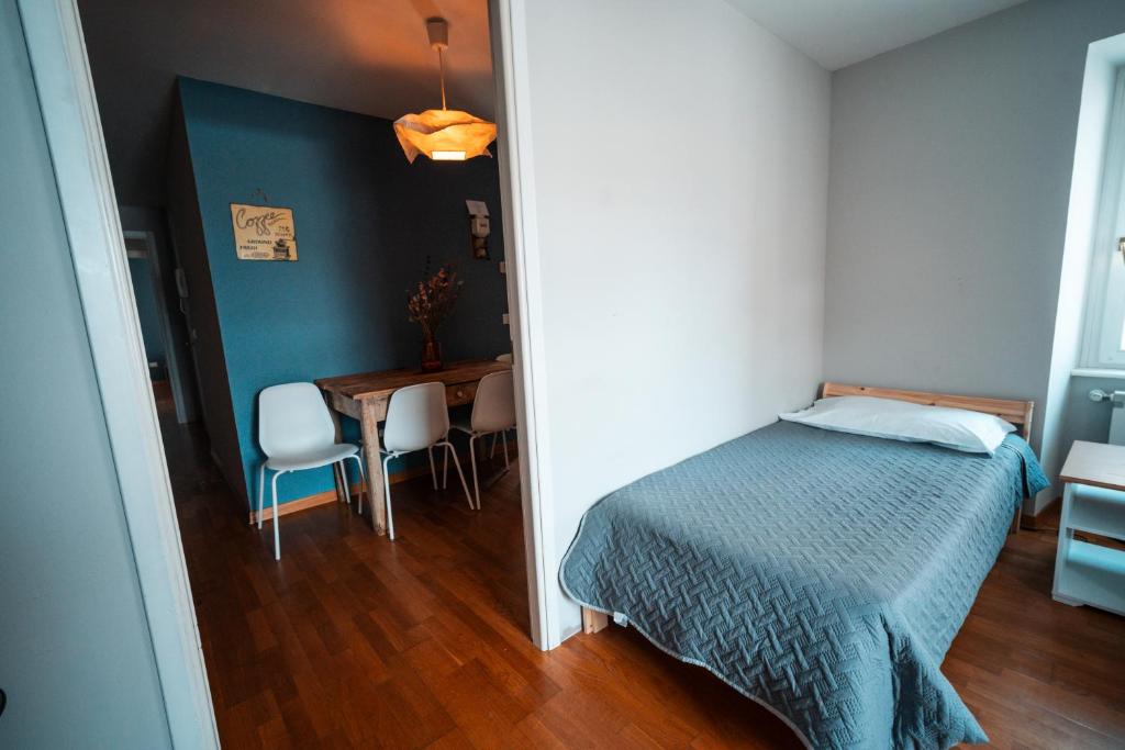 a bedroom with a bed and a table with chairs at Hurban Apartments Muggia in Muggia