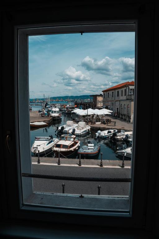 a window view of a marina with boats in the water at Hurban Apartments Muggia in Muggia