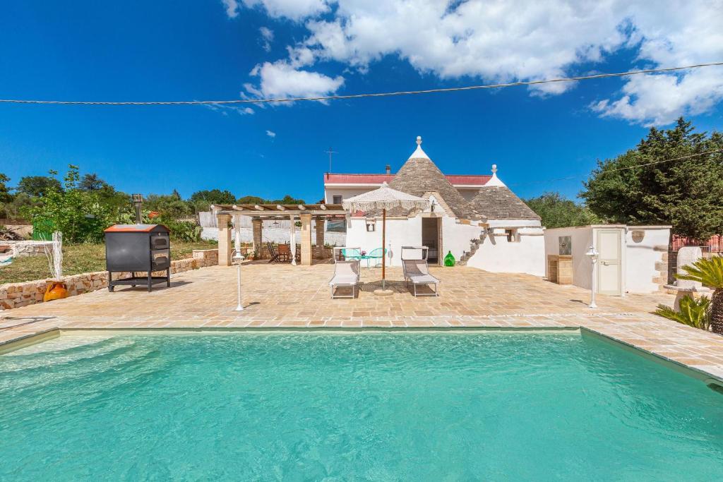 a swimming pool in front of a house at Trullo DoMi by Perle di Puglia in Noci