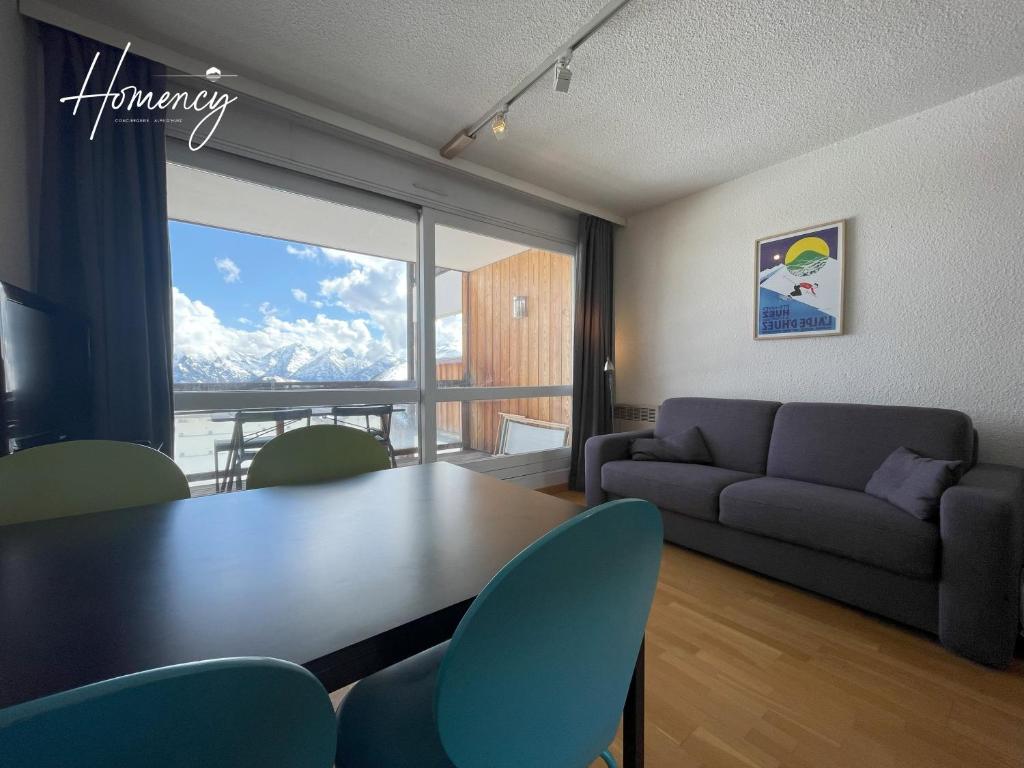 un salon avec une table et un canapé dans l'établissement Homency - Résidence Chalet des Roches 32, à L'Alpe-d'Huez