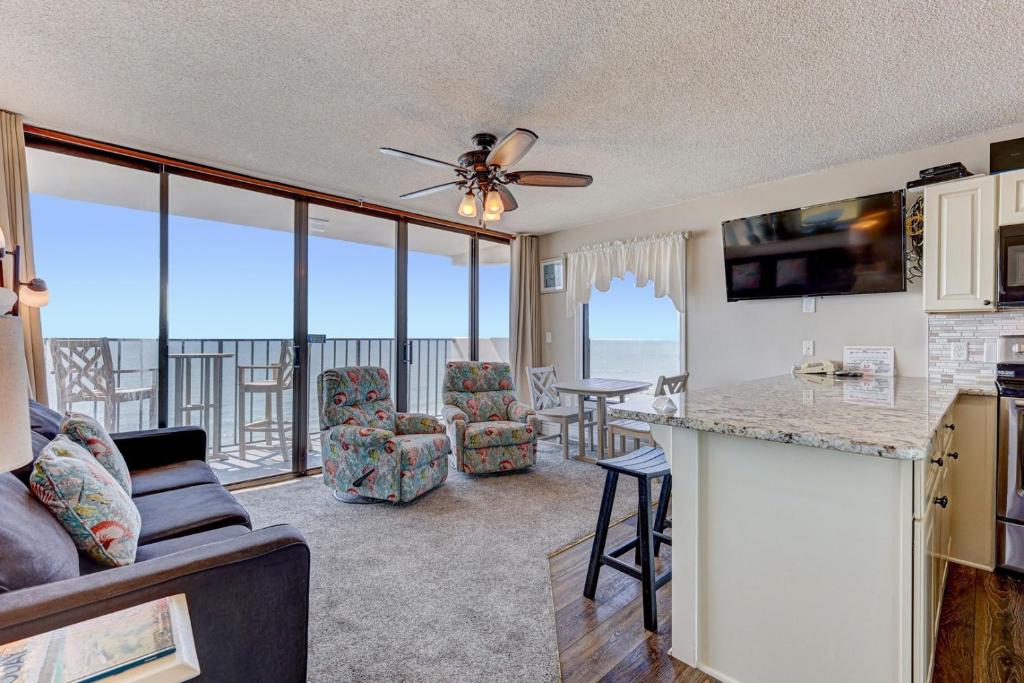 a kitchen and living room with a view of the ocean at 1114 Boundless Awe by Atlantic Towers in Carolina Beach