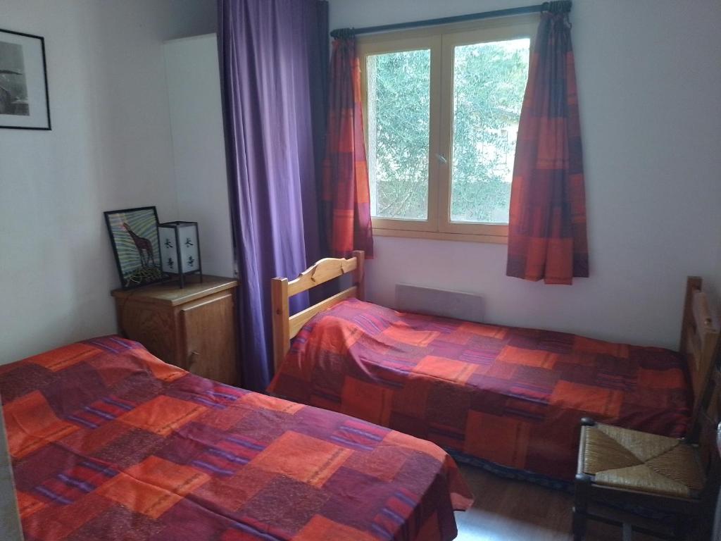 une chambre avec deux lits et une fenêtre dans l'établissement maison de vacances à Paulhan, à Paulhan