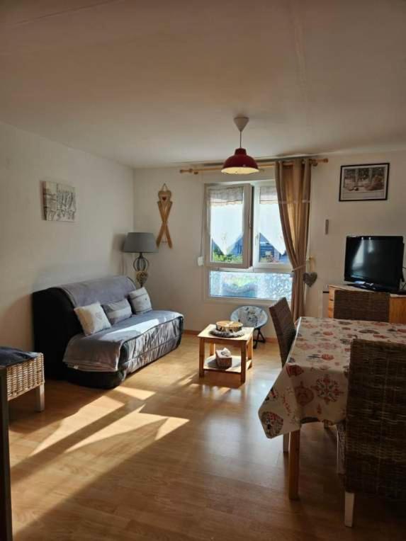 a living room with a couch and a table at résidence vallée des lacs in Le Tholy