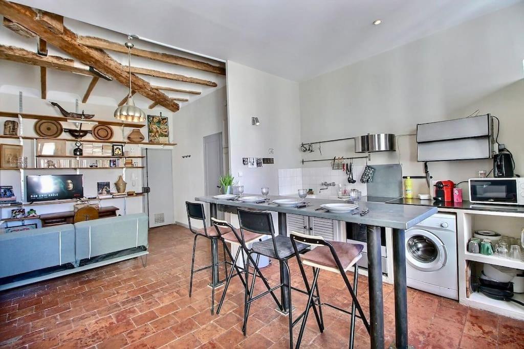 une cuisine avec une table et des chaises dans une pièce dans l'établissement SC Collection - Charme et Authenticité du Panier, à Marseille