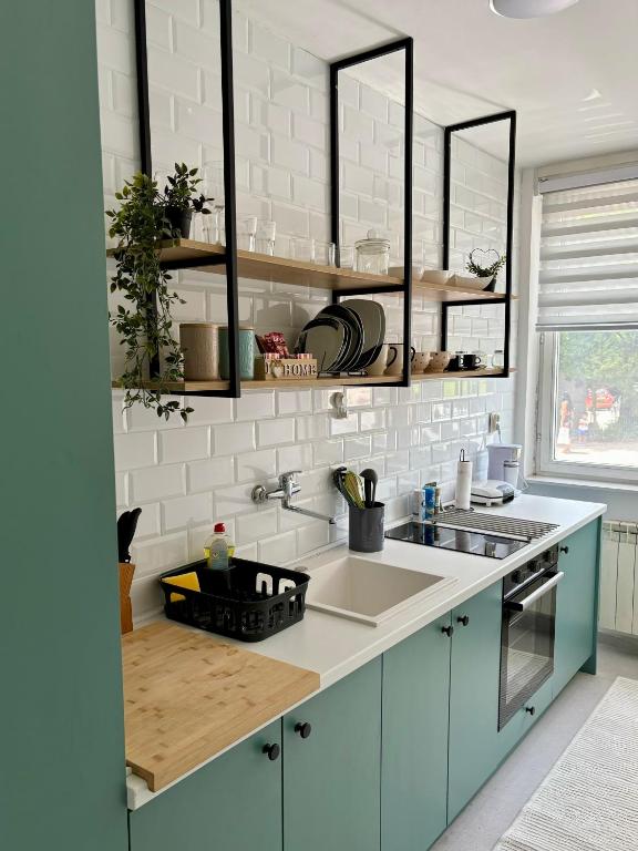 Una cocina con gabinetes azules y un fregadero. en Jenny's Place Sarajevo, en Sarajevo