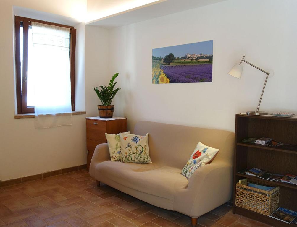 a living room with a couch and a window at Il mulino di Augusto e Marianna in Corinaldo