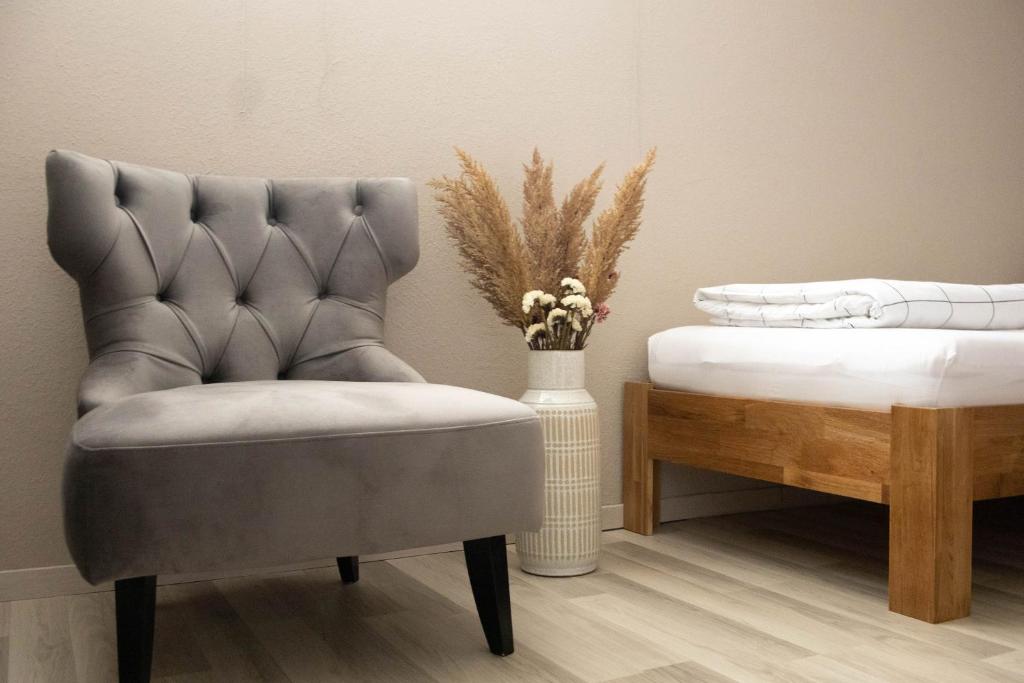 a chair and a vase with flowers in a room at Kuzey Apartments in Kappel-Grafenhausen
