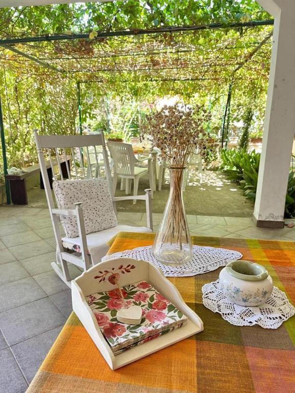 a table with a vase and a plate with flowers at Vila Klara in Olib