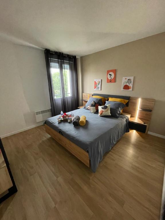 une chambre avec un grand lit avec un plancher en bois dans l'établissement Paris Disneyland appartement centre-ville, parking, au coeur de l'aviron, à Vaires-sur-Marne
