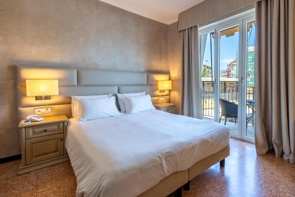 A bed or beds in a room at B&B HOTEL Diano Marina Palace