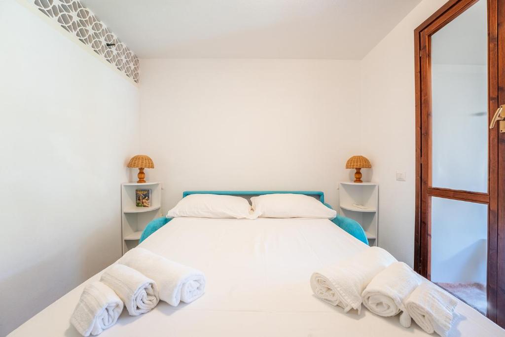 a white bedroom with a bed with towels on it at Villa Perdalonga, Vista Mare Sea View Tuerredda in Teulada