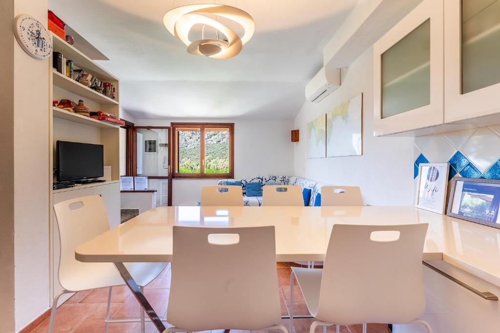 a kitchen and dining room with a table and chairs at Villa Perdalonga, Vista Mare Sea View Tuerredda in Teulada