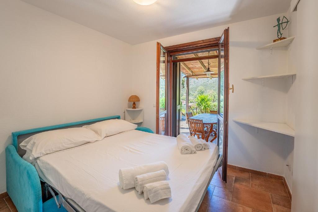 a bedroom with a bed with towels on it at Villa Perdalonga, Vista Mare Sea View Tuerredda in Teulada