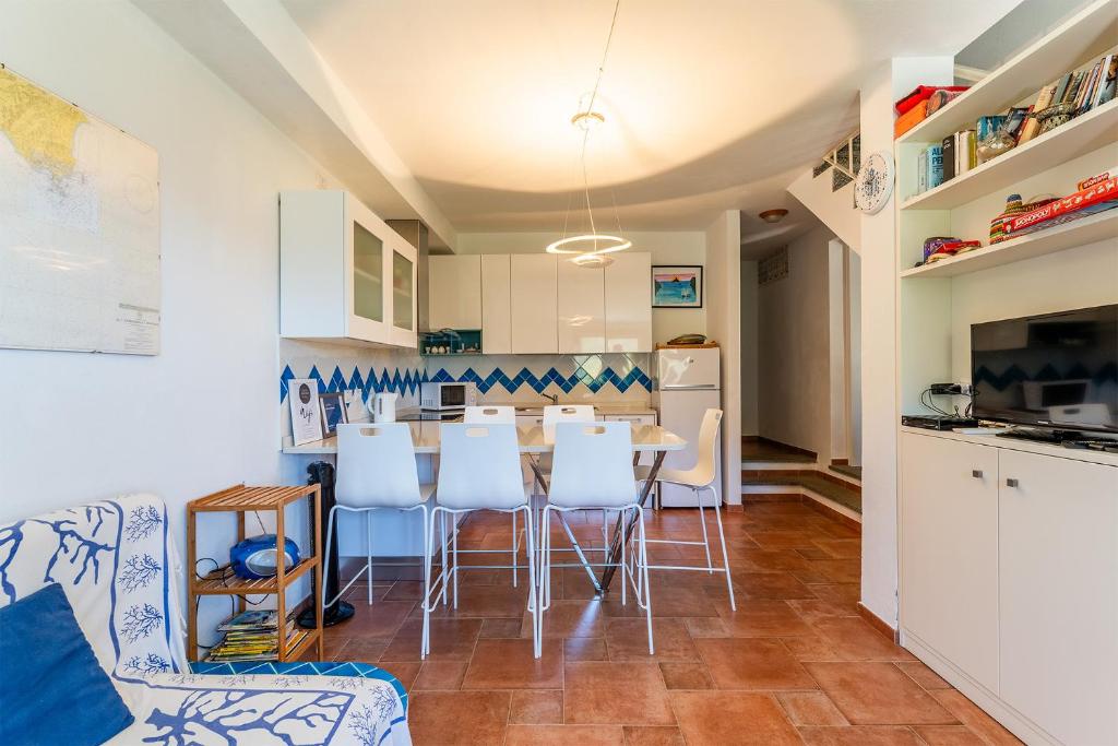 a kitchen and dining room with a table and chairs at Villa Perdalonga, Vista Mare Sea View Tuerredda in Teulada