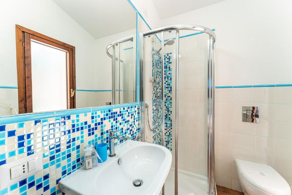 a blue and white bathroom with a sink and a shower at Villa Perdalonga, Vista Mare Sea View Tuerredda in Teulada