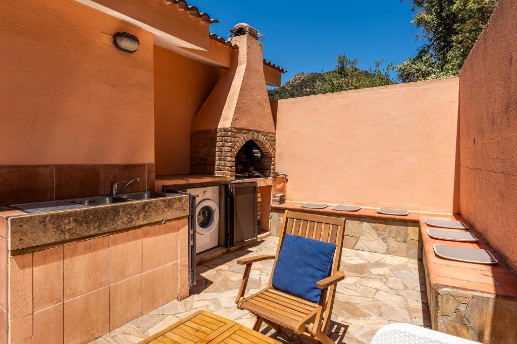 a patio with a chair and a sink and a stove at Villa Perdalonga, Vista Mare Sea View Tuerredda in Teulada