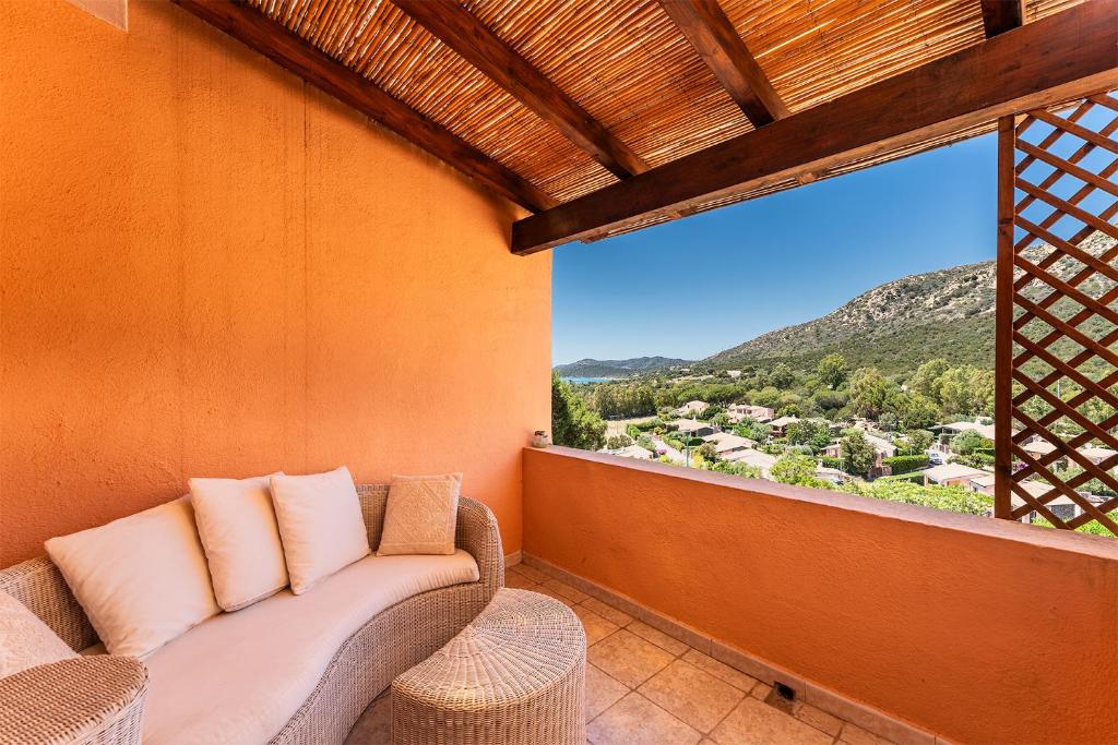 a couch sitting on a balcony with a large window at Villa Perdalonga, Vista Mare Sea View Tuerredda in Teulada