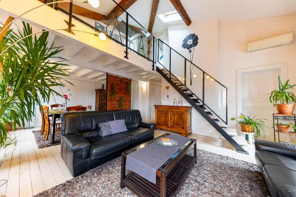 - un salon avec un canapé en cuir noir et un escalier dans l'établissement Appartement de Caractère T5 en Hypercentre, à Toulouse