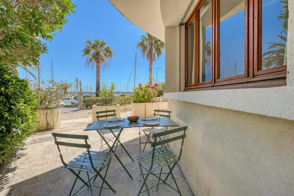 une table et des chaises installées à côté d'un bâtiment dans l'établissement Appartement Osta - Welkeys, à Bandol
