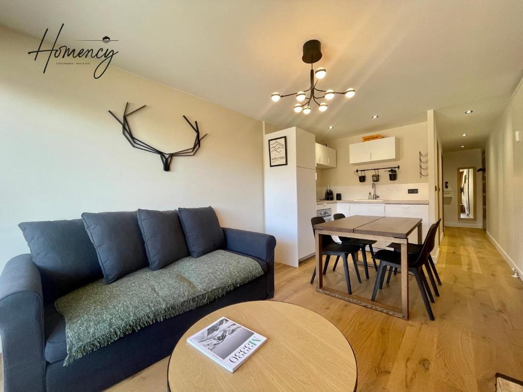 un salon avec un canapé bleu et une table dans l'établissement Homency - Résidence Hélios A1, à L'Alpe-d'Huez