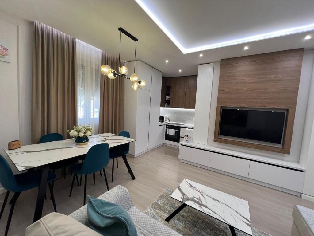 a living room with a dining table and a television at Gold Vollga House Durres in Durrës