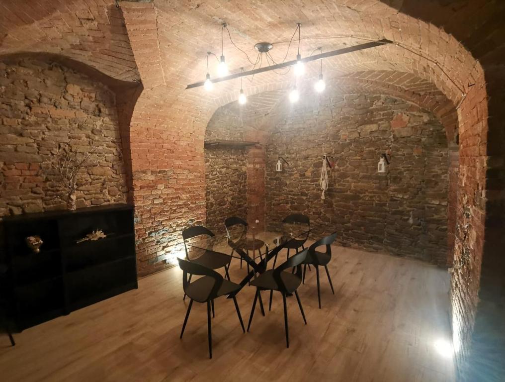 a room with a table and chairs in a brick wall at Casa del barbiere in Dogliani