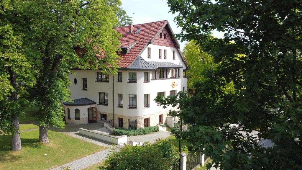 a large white house with a red roof at Jasny Dwór in Polanica-Zdrój