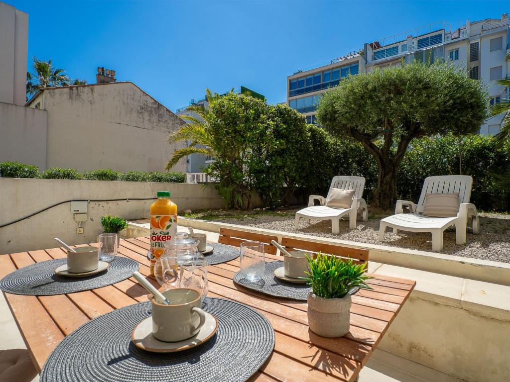 - une table en bois avec des boissons sur la terrasse dans l'établissement Apartment Cannes Bay-1 by Interhome, à Cannes