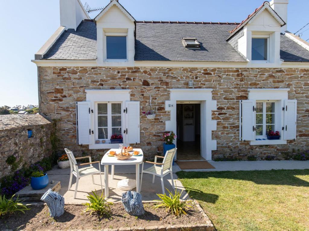 a stone house with a table and chairs in the yard at Holiday Home Les Hortensias by Interhome in Kerherneau