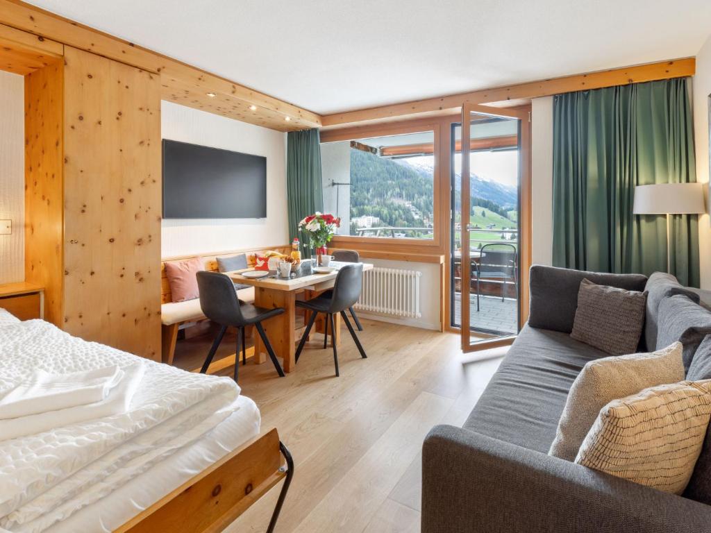 a hotel room with a bed and a dining room at Apartment Guardaval - Utoring-8 by Interhome in Davos