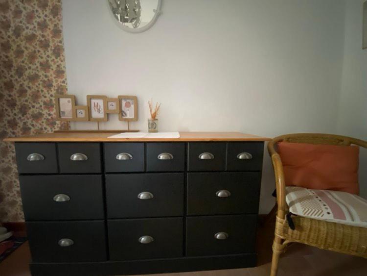 une commode dans une chambre avec une chaise et une commode dans l'établissement Maison de vacances avec piscine à Grignan-Drôme provençale, à Grignan