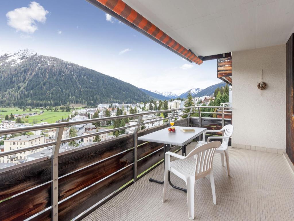 a balcony with a table and chairs and mountains at Apartment Guardaval Apt 202 by Interhome in Davos