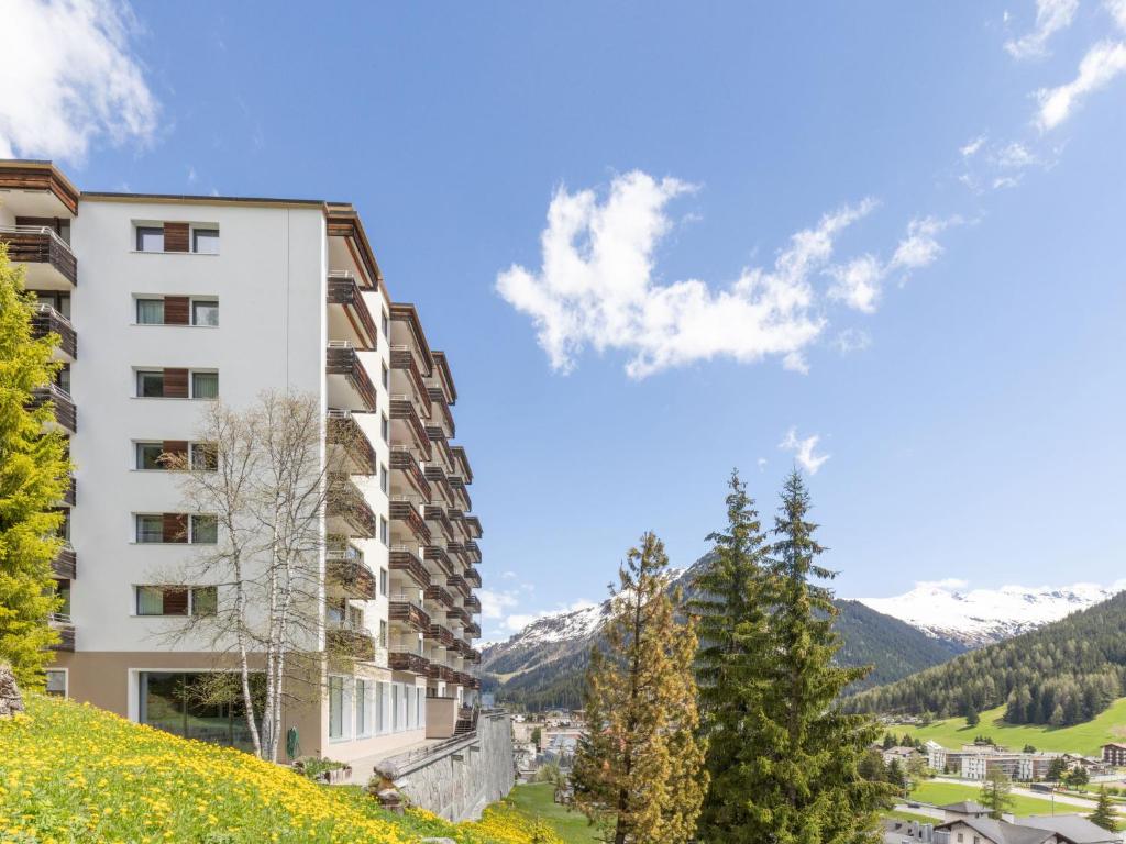 a building on a hill with mountains in the background at Apartment Guardaval Apt 508 by Interhome in Davos