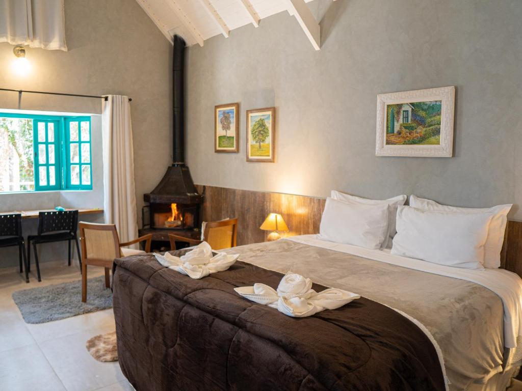 a bedroom with a large bed with towels on it at Pousada Vila Suiça - Monte Verde in Monte Verde