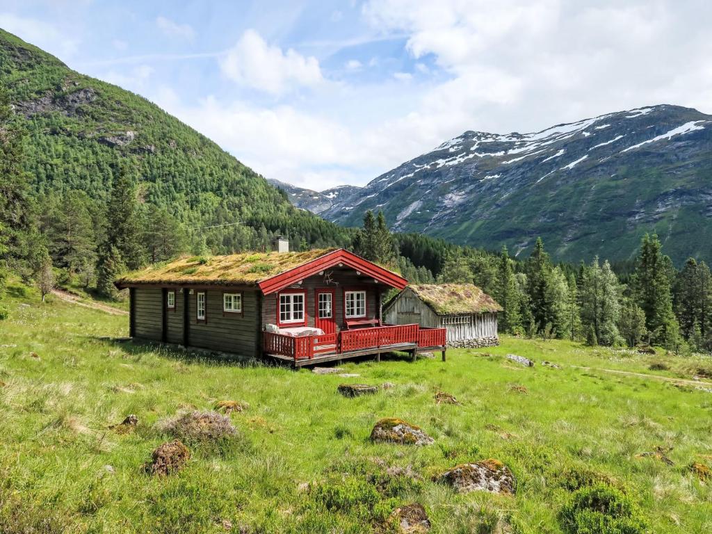 a house in a field with mountains in the background at Chalet Fjellbris by Interhome in Holsen