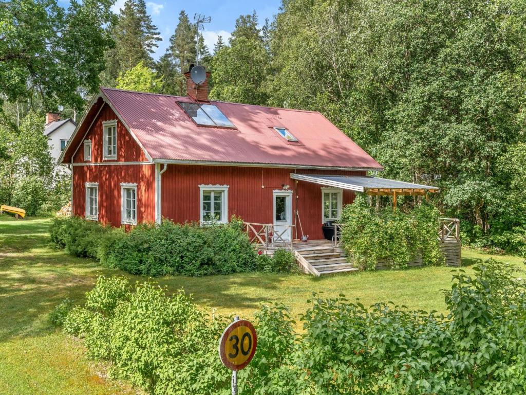 a red house with a sign in front of it at Chalet Bäcklunda by Interhome in Mullhyttan