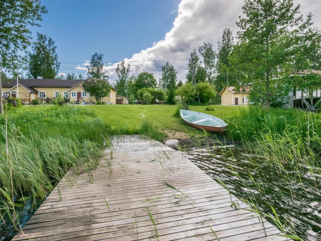 ein Holzsteg mit einem Boot auf einem Feld in der Unterkunft Holiday Home Kannashovi by Interhome in Taipale