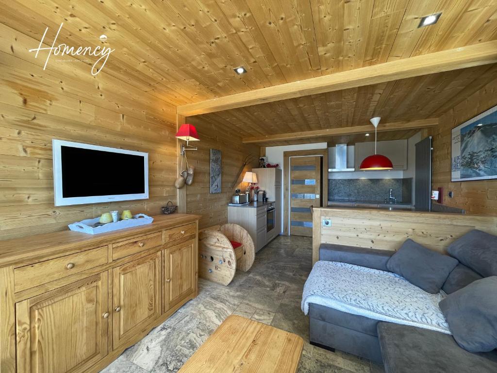 salon z kanapą i telewizorem z płaskim ekranem w obiekcie Homency - Résidence Saint Laurent C1 w LʼAlpe-dʼHuez