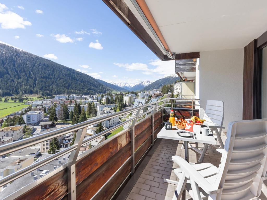 a balcony with a table and chairs and mountains at Apartment Guardaval - Utoring-66 by Interhome in Davos