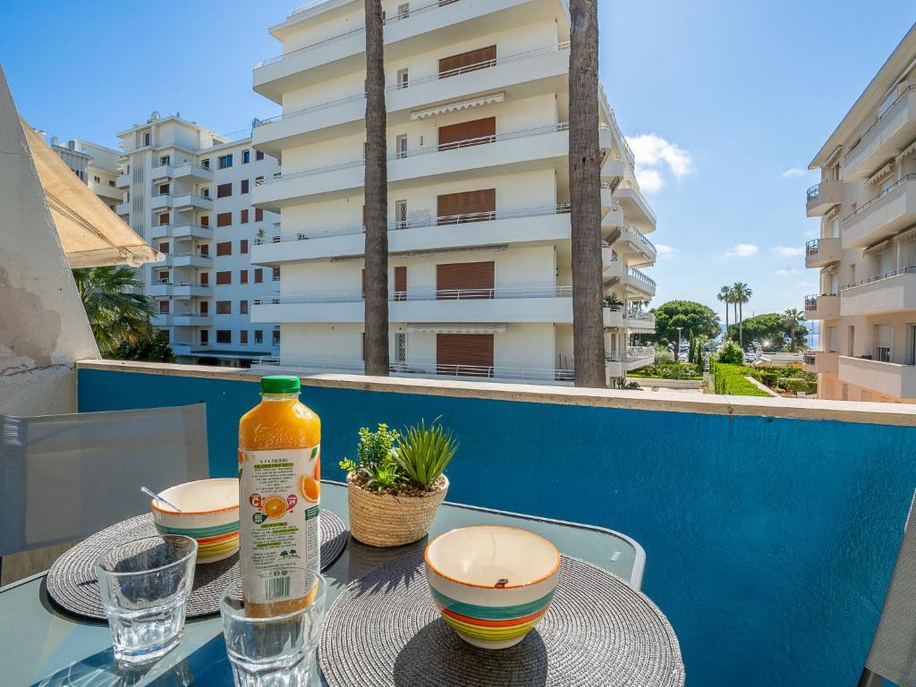 une table avec deux bols et une bouteille sur un balcon dans l'établissement Apartment Le Marlyne 1 by Interhome, à Cannes
