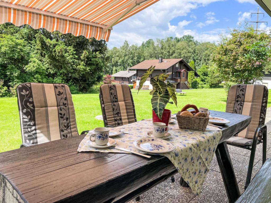 a wooden table with a table cloth and a basket on it at Holiday Home Am Hohen Bogen-49 by Interhome in Arrach