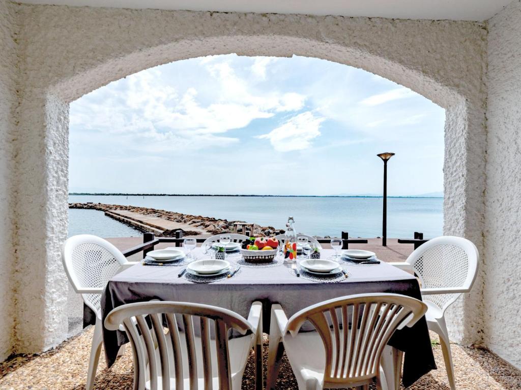 - une table à manger avec des chaises et une vue sur l'océan dans l'établissement Apartment Coudalère-Guadeloupe-3 by Interhome, au Barcarès