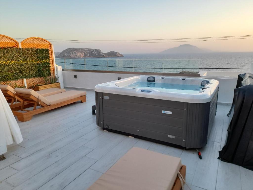 a hot tub on a balcony with a view of the ocean at Hotel Finiki View in Foiníkion