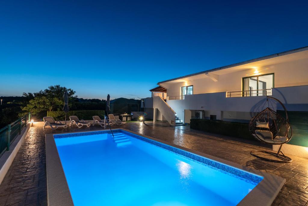 eine Villa mit Swimmingpool bei Nacht in der Unterkunft Villa Alina with heated pool in Rogoznica