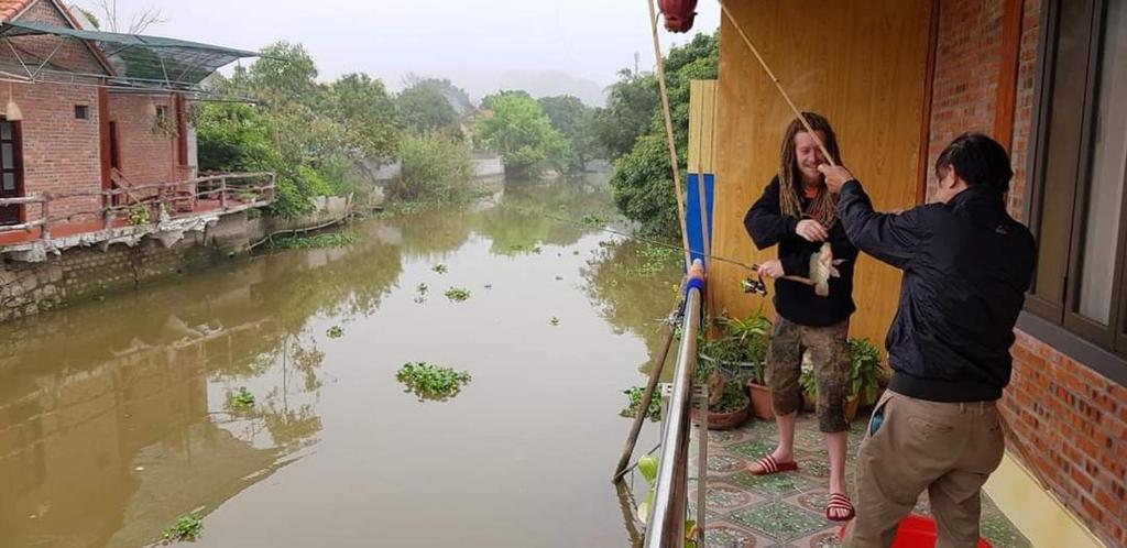 a man and a woman on a boat in a river at Tam Coc Paradise Homestay in Ninh Binh