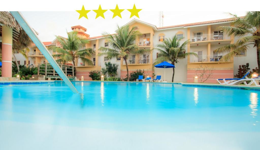 a large swimming pool in front of a hotel at Ocean Dream top floor apt with balcony in Cabarete